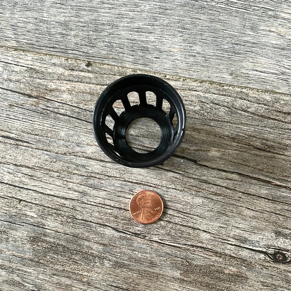 a 1 5/8" tiny black net pot with a penny for size - looking down from the top to the bottom hole
