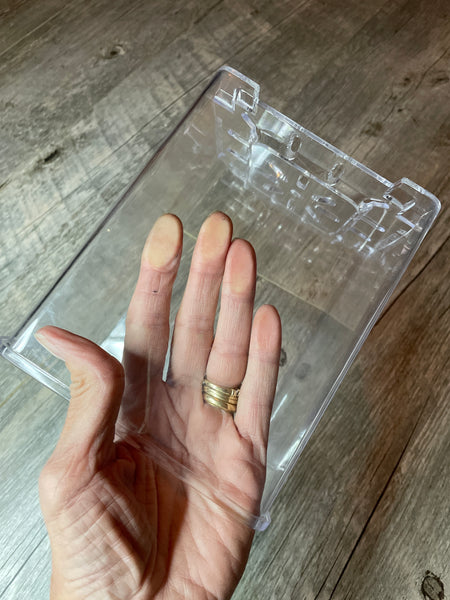 a hand inside a 5" clear plastic square pot showing the clarity