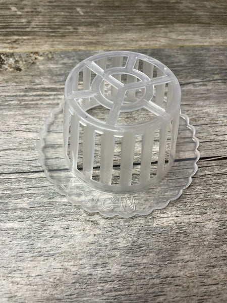 The bottom of a 4” scalloped edge clear plastic orchid basket