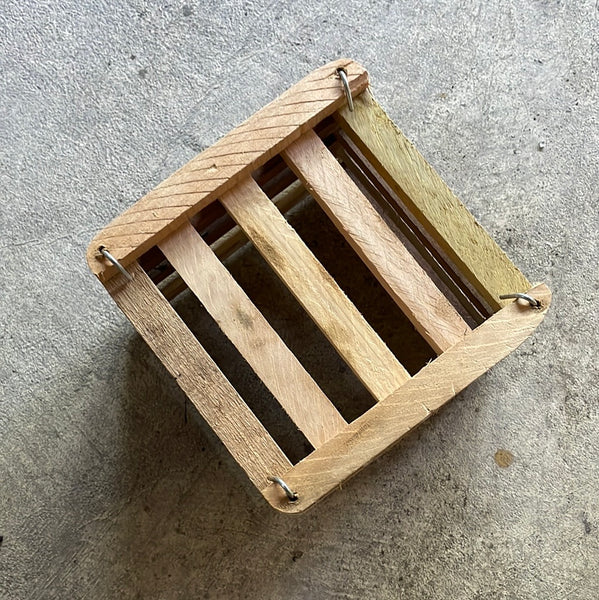 the bottom of a 6 inch wooden orchid basket showing the slats